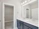 Bathroom with double vanity, white countertop, and open door to walk-in closet at 16526 Silver Brook Way, Winter Garden, FL 34787
