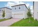 A two-story home featuring a brick driveway, green lawn, and blue siding on the second floor at 16526 Silver Brook Way, Winter Garden, FL 34787