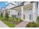 Inviting front porch with stone accents, iron railing, and a quaint brick walkway at 16526 Silver Brook Way, Winter Garden, FL 34787