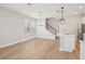 Open-concept living area with hardwood floors, modern lighting, and staircase at 16526 Silver Brook Way, Winter Garden, FL 34787
