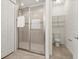 Bathroom featuring tiled floors, glass shower, and a separate toilet area with wire shelving at 18920 Overton St, Orlando, FL 32833