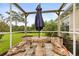 Charming outdoor seating area with a stone table and benches inside a screened enclosure at 18920 Overton St, Orlando, FL 32833