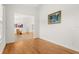 Bright room featuring hardwood floors, a glimpse of an adjacent room, and decorative artwork on the wall at 18920 Overton St, Orlando, FL 32833