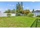 Back yard with green grass, small trees and flower garden that is bordered by a white fence at 1930 Aster Dr, Winter Park, FL 32792
