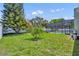 Well-maintained back yard with green grass, trees, flower garden and screened in pool at 1930 Aster Dr, Winter Park, FL 32792