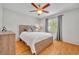 Cozy bedroom features hardwood floors, gray curtains, ceiling fan and natural light from the window at 1930 Aster Dr, Winter Park, FL 32792