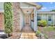 Inviting front porch with stone accents, tiled floor, and a wooden front door with glass details at 1930 Aster Dr, Winter Park, FL 32792