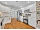 Modern kitchen with stainless steel appliances, double oven, white cabinets, and open shelving for storage at 1930 Aster Dr, Winter Park, FL 32792