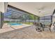 View of the in-ground pool with surrounding patio and table with chairs under the screened enclosure at 1930 Aster Dr, Winter Park, FL 32792