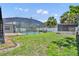 View of the in-ground swimming pool that is surrounded by a screened enclosure and the back yard at 1930 Aster Dr, Winter Park, FL 32792