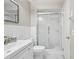 Bright bathroom features a walk-in shower with glass doors, white subway tile and single sink vanity at 2020 Cocos Ct, Winter Park, FL 32792