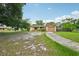 Single-story home featuring a quaint, light brown exterior with an attached garage and a spacious front yard at 2020 Cocos Ct, Winter Park, FL 32792