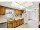 Functional kitchen with tile countertops, wood cabinets, and a view into the dining area at 2020 Cocos Ct, Winter Park, FL 32792