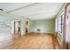 Open-concept living room featuring hardwood floors, plenty of light, and access to the kitchen and sunroom at 2020 Cocos Ct, Winter Park, FL 32792