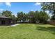 Expansive grassy back yard with mature trees and fire pit, perfect for outdoor entertaining at 2305 Ascot Ave, Orlando, FL 32833
