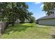 Large private backyard with a shed and shaded by mature trees and shrubbery at 2305 Ascot Ave, Orlando, FL 32833