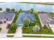 Aerial view of a blue home with lush landscaping and a view of a lake at 2440 Pawtucket Pass, Mount Dora, FL 32757