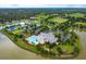 Aerial shot of the community clubhouse, pool, tennis courts, and surrounding landscape near a lake at 2440 Pawtucket Pass, Mount Dora, FL 32757