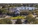 An aerial shot showcases the beautiful clubhouse with palm trees, lush landscaping and lake views at 2440 Pawtucket Pass, Mount Dora, FL 32757