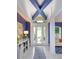 Entryway with blue accents, white trim, and modern lighting fixtures at 2440 Pawtucket Pass, Mount Dora, FL 32757
