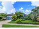 Charming blue home with a well-maintained lawn and lush landscaping at 2440 Pawtucket Pass, Mount Dora, FL 32757