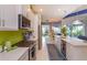 Open-concept kitchen with white cabinets, stainless steel appliances, and an island, flowing into the dining and living areas at 2440 Pawtucket Pass, Mount Dora, FL 32757