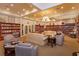 Comfortable library with sofas, armchairs, and extensive bookshelves filled with books at 2440 Pawtucket Pass, Mount Dora, FL 32757