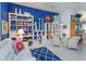 Bright living room showcasing modern decor, white seating, shelving, and vibrant colors at 2440 Pawtucket Pass, Mount Dora, FL 32757