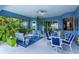 Relaxing covered patio with stylish seating, lush landscaping, and a ceiling fan for comfortable outdoor living at 2440 Pawtucket Pass, Mount Dora, FL 32757