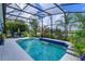 The pool area includes a screened enclosure, lounge chairs, and lush tropical landscaping with a water view at 2440 Pawtucket Pass, Mount Dora, FL 32757