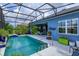 Inviting pool area with screened enclosure, showcasing seamless indoor-outdoor living and colorful landscaping at 2440 Pawtucket Pass, Mount Dora, FL 32757