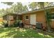 Back of house featuring screened-in lanai, mature landscaping, lush greenery, and AC system at 3141 Cashmere Dr, Orlando, FL 32827
