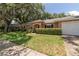 Charming single-story home features a lush green lawn and mature landscaping, creating inviting curb appeal at 3141 Cashmere Dr, Orlando, FL 32827