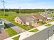 Areal view of a tan house with manicured lawns and a brick driveway at 3279 Canna Lily Pl, Clermont, FL 34711