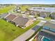 Scenic aerial view of a residential community with well-maintained lawns and a tranquil lake in the background at 3279 Canna Lily Pl, Clermont, FL 34711