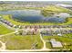Community aerial view showcasing the home's location near a serene lake, highlighting its desirable setting at 3279 Canna Lily Pl, Clermont, FL 34711