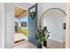 Inviting entryway with a stylish blue front door, a welcoming wreath, and a peek into the home's bright interior at 3279 Canna Lily Pl, Clermont, FL 34711