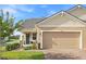 Charming single-Gathering home featuring a brick driveway, two-car garage, and covered porch at 3279 Canna Lily Pl, Clermont, FL 34711