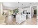 Bright, open kitchen featuring a large center island with quartz countertops and stainless steel appliances at 3279 Canna Lily Pl, Clermont, FL 34711