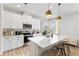 Stylish kitchen featuring a center island with bar stools, white cabinets, and modern stainless steel appliances at 3279 Canna Lily Pl, Clermont, FL 34711