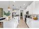 Well-lit kitchen boasts white cabinetry, stainless steel appliances, and a modern island with pendant lighting at 3279 Canna Lily Pl, Clermont, FL 34711