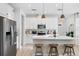 Modern kitchen with a center island, bar stool seating, bright lighting, and stainless steel appliances at 3279 Canna Lily Pl, Clermont, FL 34711