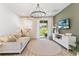 Bright living room features a decorative chandelier, neutral tones, and sliding glass doors to the backyard at 3279 Canna Lily Pl, Clermont, FL 34711