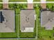 Aerial view of three homes showcasing well-maintained lawns and neatly arranged roofs in a suburban neighborhood at 3849 Kimbolton Way, Sanford, FL 32773