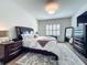 This primary bedroom features a large bed, stylish furnishings and a patterned rug at 3849 Kimbolton Way, Sanford, FL 32773