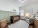 Charming Bedroom features a wooden crib, accent wall, glider, and airplane-themed decor at 3849 Kimbolton Way, Sanford, FL 32773