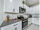 Modern kitchen features granite countertops, stainless steel appliances, and classic white cabinets with black hardware at 3849 Kimbolton Way, Sanford, FL 32773