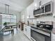 Modern kitchen featuring stainless steel appliances, granite countertops, and a dining area with backyard views at 3849 Kimbolton Way, Sanford, FL 32773