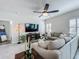 Bright living room features tile floors, a ceiling fan, a large sectional sofa, and a media console at 3849 Kimbolton Way, Sanford, FL 32773