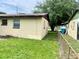 An exterior view shows the chain-link fenced in back yard with healthy green grass at 4394 Prince Hall Blvd, Orlando, FL 32811